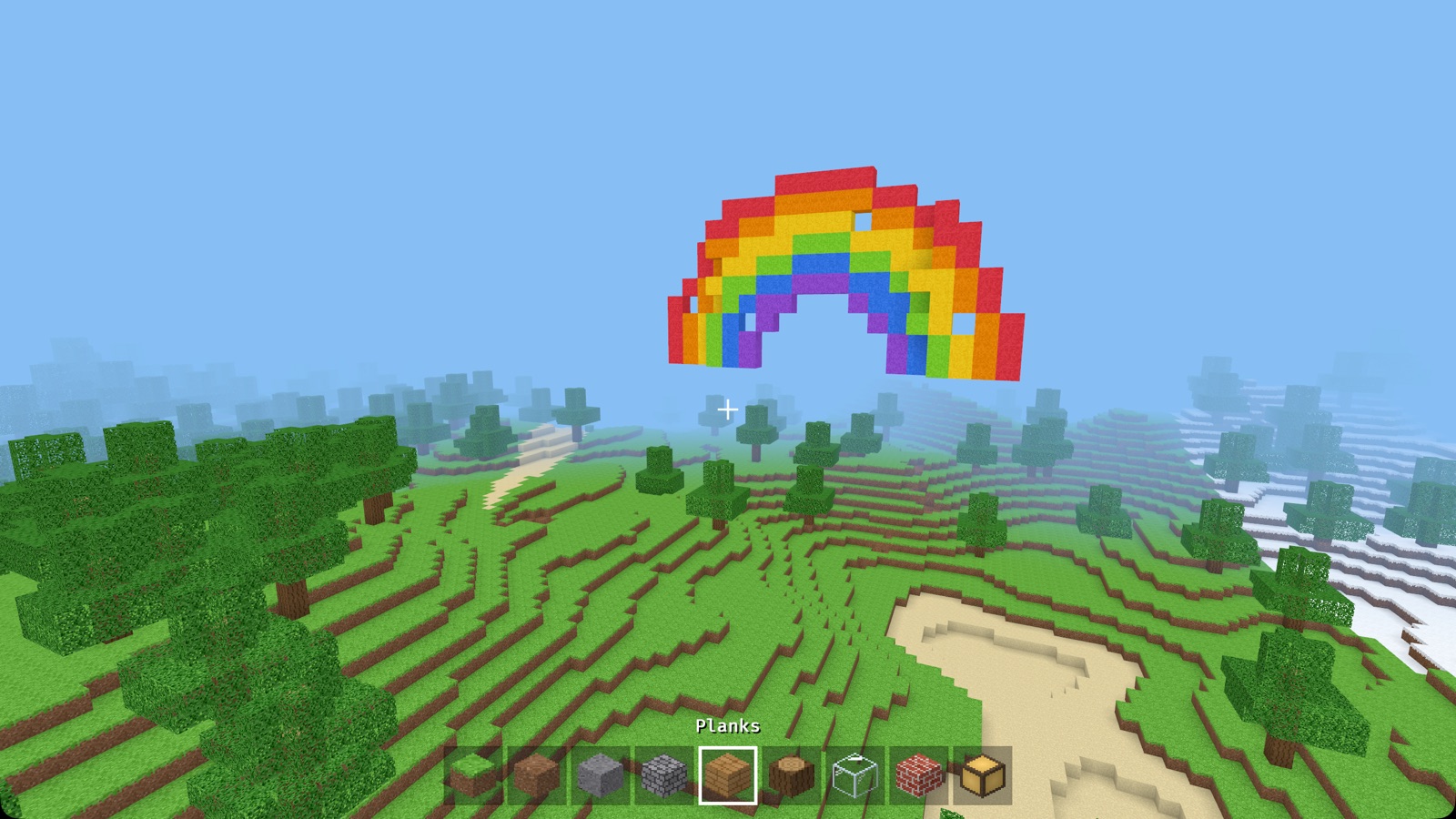 A rainbow built from coloured blocks over green hills
